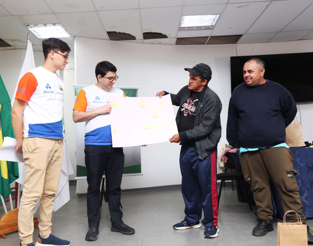 Voluntários da Alcoa e Toninho, que atua com reciclagem, durante apresentação do plano de ações